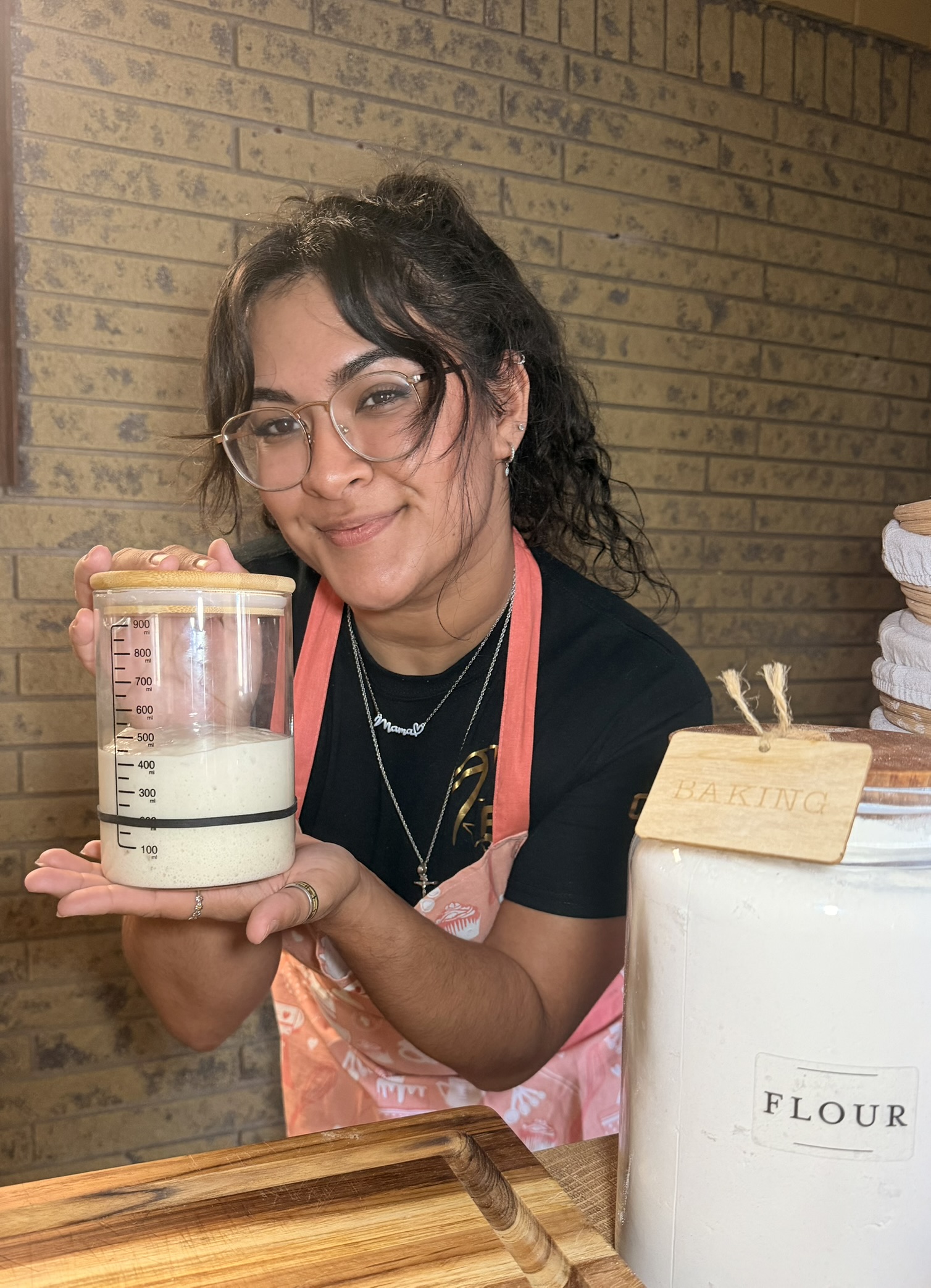 Amber, baker and founder of Heavenly & Crumb, holding sourdough starter Edna